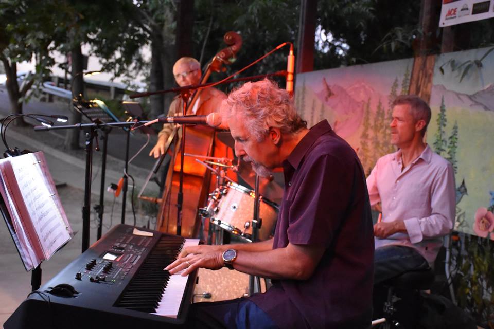 Photo of three men playing instruments outside